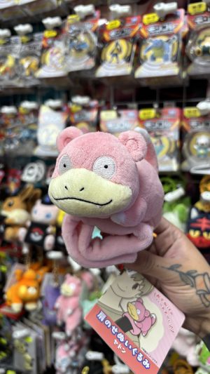 THEVOLTAGE.CL POKEMON CENTER ACCESORIOS PELUCHE MOCHILA GIRATORIO SLOWPOKE